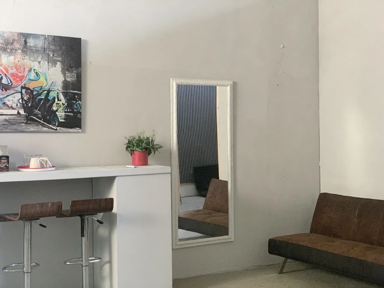 Relax room to unwind, bar stools, mirror, artwork, and seating furniture